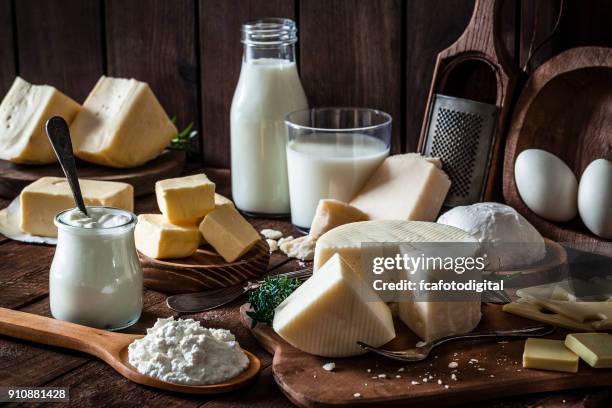 produits laitiers tourné sur une table en bois rustique - dairy product stock photos et images de collection