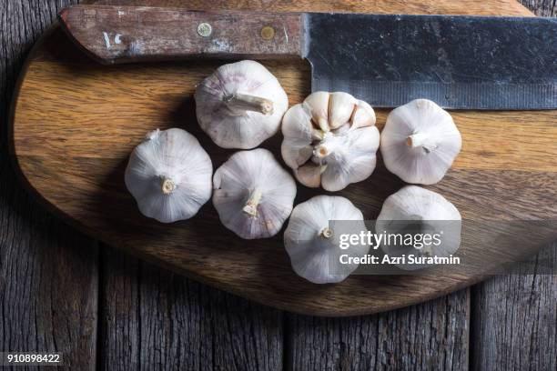 garlic on wooden chopping board. - chopping garlic stock pictures, royalty-free photos & images