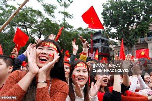 Vietnamese football fans cheer for the Vietnamese team as they watch a television broadcast in Hanoi on January 27, 2018 showing the 2018 AFC U-23...