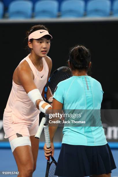 Xinyu Wang of China and En Shuo Liang of Taipei talk tactics in the Junior Girls' Doubles Final against Violet Apisah of Papua New Guinea and Lulu...