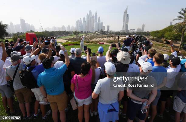 Spectators watch as Rory McIlroy of Northern Ireland tees off on the 8th hole during day three of Omega Dubai Desert Classic at Emirates Golf Club on...