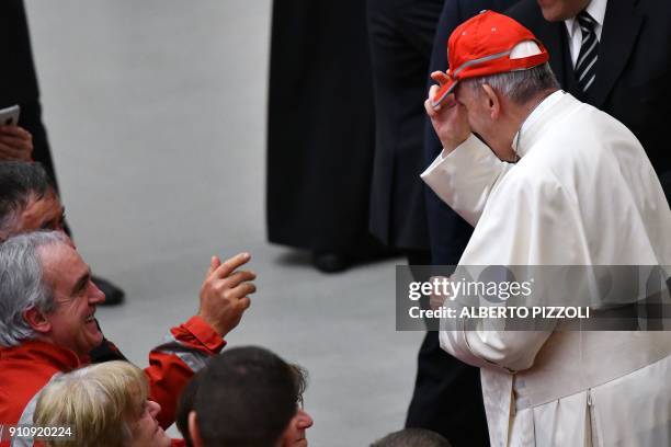 Pope Francis wears a Red Cross cap during the audience with members of the Italian Red Cross and Red Crescent in the Paul VI hall at the Vatican on...