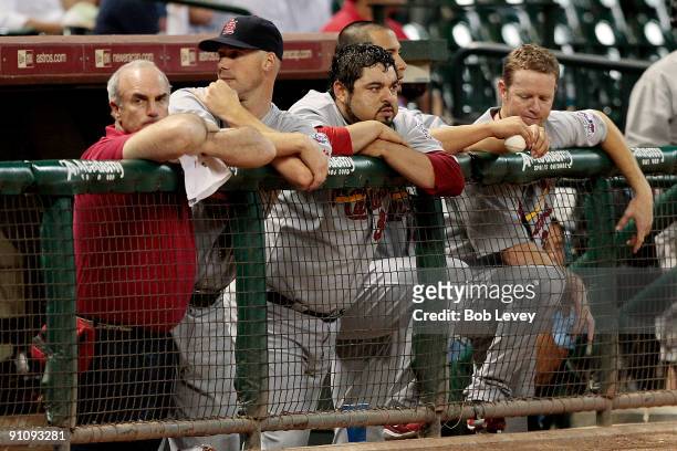 Trainer Barry Weinberg of the St. Louis Cardinals along with pitchers Chris Carpenter and Dennys Reyes # #36 looks on from the bench in the ninth...