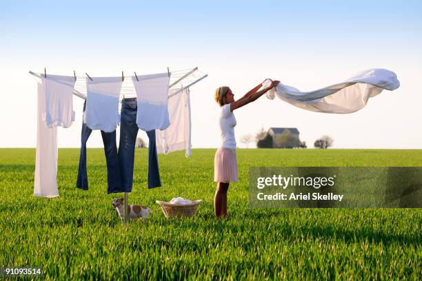 young woman doing laundry in field - clothesline imagens e fotografias de stock