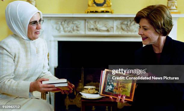 Turkish First Lady Emine Erdogan presents US First Lady Laura Bush with a book during a coffee meeting at the White House, Washington DC, January 29,...