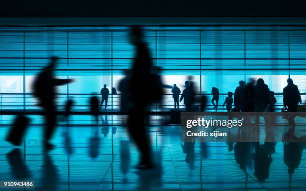 mensen lopen van reflectie in de bandbreedte van de luchthaven - arrivals stockfoto's en -beelden