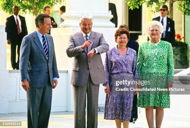 On the White House's North Portico, US President George HW Bush and First Lady Barbara Bush pose with Russian Federation President Boris Yeltsin and...