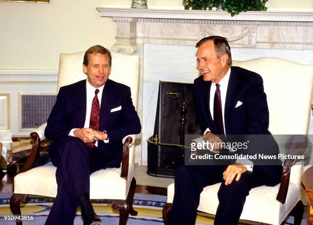 Czech President Vaclav Havel and US President George HW Bush talk together in the White House's Oval Office, Washington DC, October 22, 1991.