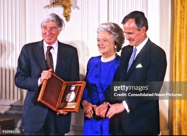 American author and critic John Updike is awarded the National Medal of Arts by US First Lady Barbara Bush and President George HW Bush during a...