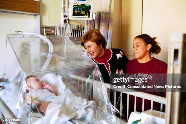 First Lady Laura Bush visits with 4-month-old Devon Garner and his mother, Tracy Garner, at the Children's National Medical Center during an annual...