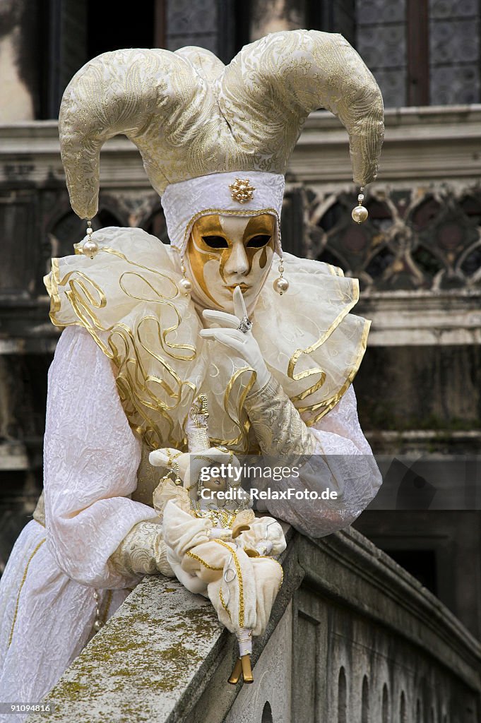 Female mask with white Jester costume at carnival in Venice