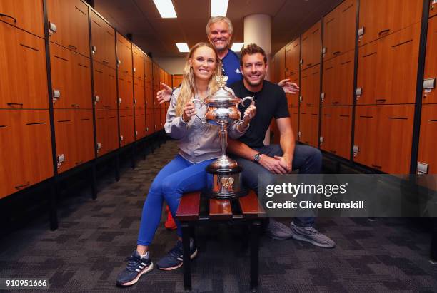 Caroline Wozniacki of Denmark poses with fiance David Lee and father Piotr with the Daphne Akhurst Trophy in the locker room after winning the...