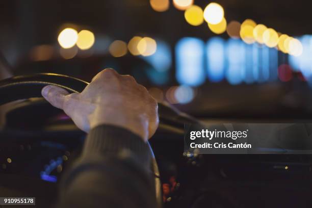 hand on steering wheel - driving a car at night stock pictures, royalty-free photos & images