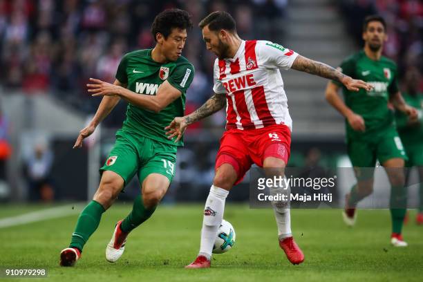 Koo Ja-Cheol of Augsburg and Marco Hoger of 1.FC Koeln battle for the ball during the Bundesliga match between 1. FC Koeln and FC Augsburg at...