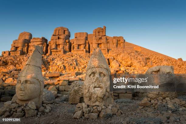 heads of statues on east terrace of mount nemrut in turkey - nemrut dag stock pictures, royalty-free photos & images
