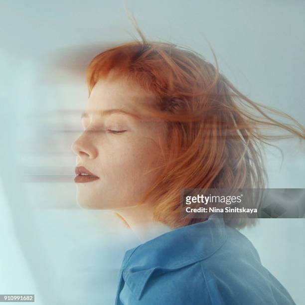 red haired woman in motion, blurred motion - long exposure - double face photos et images de collection