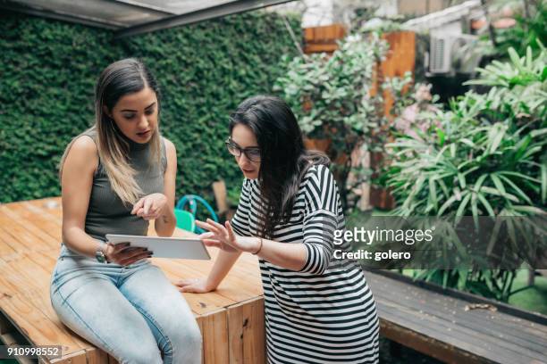 two woman working together outdoors at desk - founder stock pictures, royalty-free photos & images