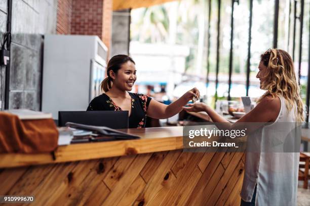 recepcionista entrega las llaves a los huéspedes a su llegada - turismo responsable fotografías e imágenes de stock