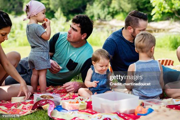 millennials families having a picnic outdoors in summer. - toddler eating sandwich stock pictures, royalty-free photos & images