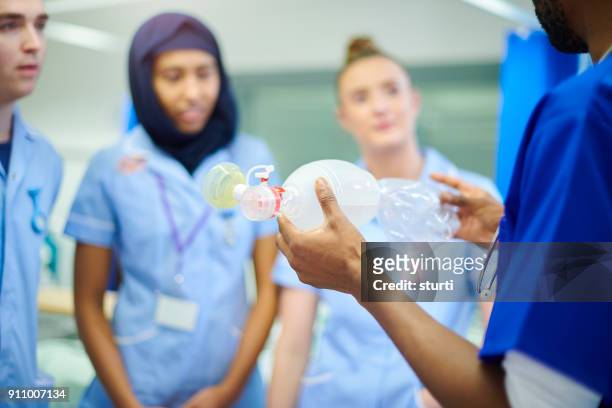 senior nurse demonstrating apparatus to students - baby accessories the dummy imagens e fotografias de stock