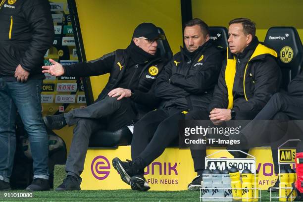 Head coach Peter Stoeger of Dortmund speak with Manfred Schmid of Dortmund and Joerg Heinrich of Dortmund during the Bundesliga match between...