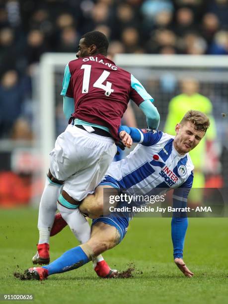 Pedro Mba Obiang of West Ham United goes off injured after this challenge with Max Power of Wigan Athletic during the The Emirates FA Cup Fourth...