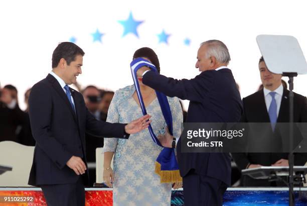 Honduran National Congress President Mauricio Oliva delivers the presidental sash to reelected President Juan Orlando Hernandez, next to First Lady...