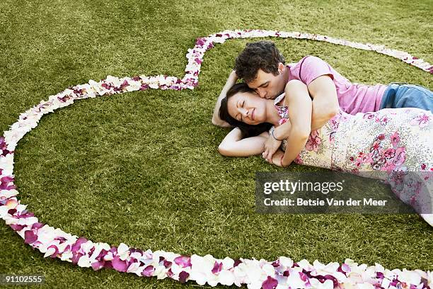 man cuddling and kissing woman.   - betsie van der meer stock pictures, royalty-free photos & images