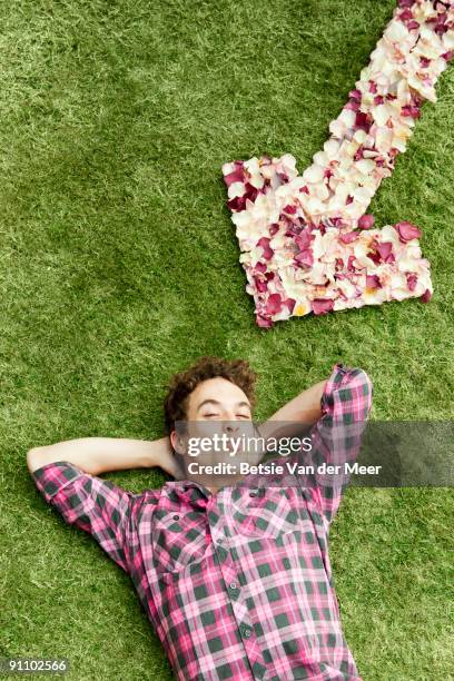 man with arrow of rosepedals. - betsie van der meer stock pictures, royalty-free photos & images