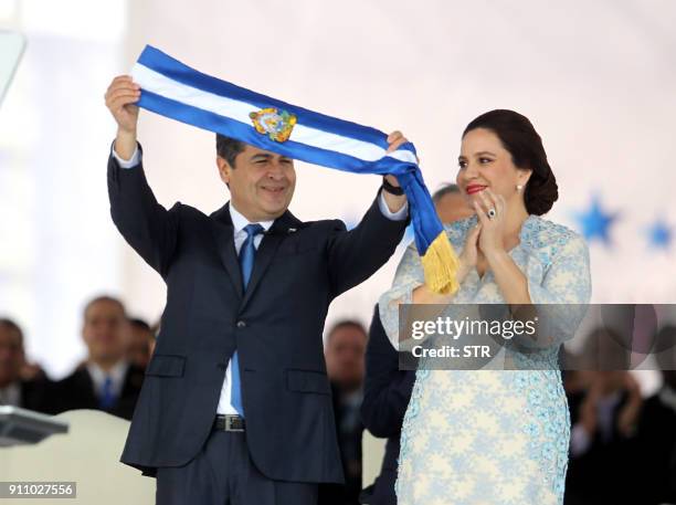 Reelected Honduran President Juan Orlando Hernandez holds the presidental sash next to First Lady Ana García at the Tiburcio Carias Andino national...