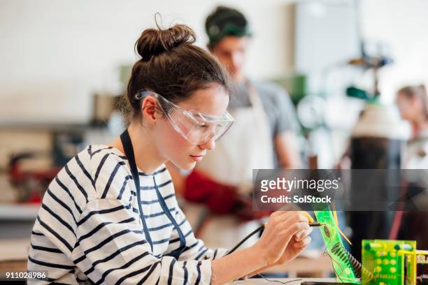 tiener meisje in de klas van de stam - metal workshop stockfoto's en -beelden