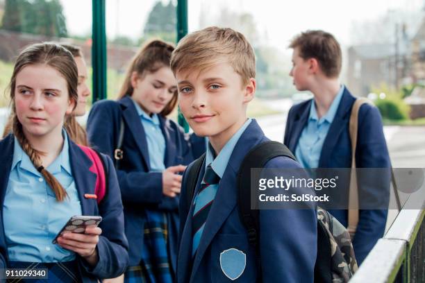 waiting for the bus - school uniform stock pictures, royalty-free photos & images