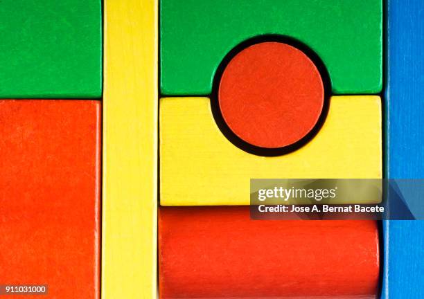 background of colored wooden blocks of rectangular, circular, cylindrical and square geometric shape. - wooden square puzzle stock pictures, royalty-free photos & images