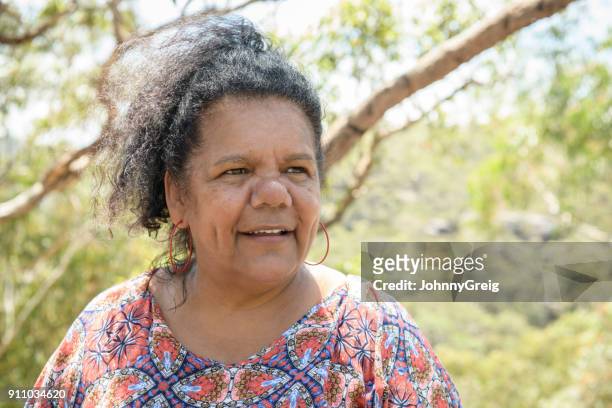 aborigines frau lächelnd und wegsehen - native australian plants stock-fotos und bilder