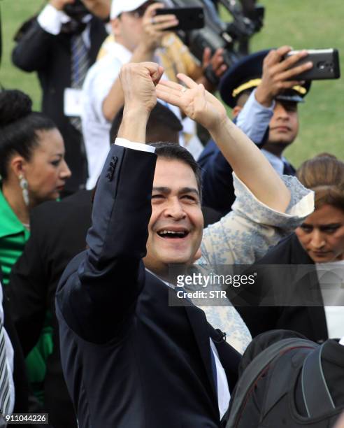 Reelected President Juan Orlando Hernandez waves to the crowd at his arrival to the inauguration ceremony at the Tiburcio Carias Andino national...