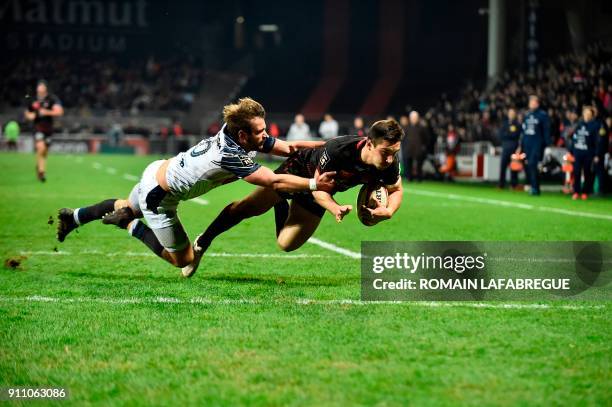 Lyon's scrumhalf Baptiste Couilloud scores a try despite Agen's scrumhalf Paul Abadie during the French Top 14 rugby union match between Lyon and...