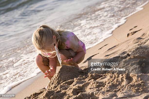 girl making a sand castle on the beach - kenni stock pictures, royalty-free photos & images
