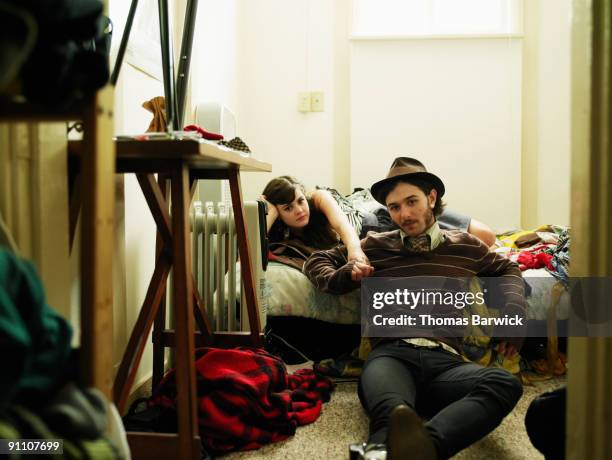 young couple in chaotic bedroom holding hands - messy boyfriend stock pictures, royalty-free photos & images