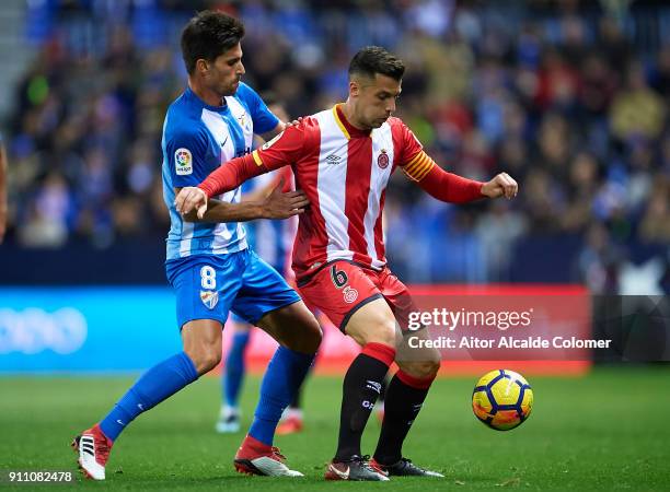 Adrian Gonzalez of Malaga CF competes for the ball with Alex Granell of Gerona FC during the La Liga match between Malaga and Girona at Estadio La...