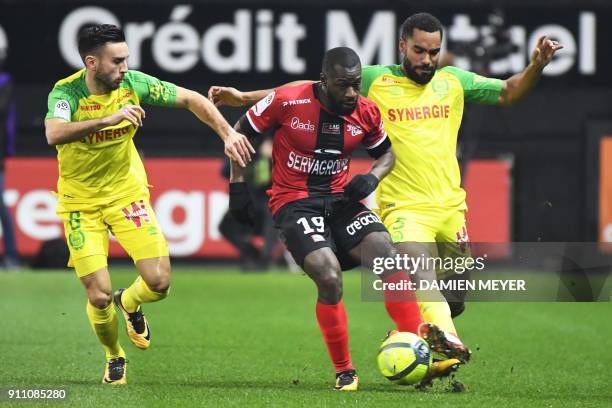 Guingamp's French midfielder Yannis Salibur vies with Nantes' French midfielder Adrien Thomasson and Nantes' French defender Levy Koffi Djidji during...