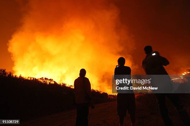 People photograph uncontrolled flames on the eastern flank of the 16,000-plus-acre Guiberson fire, burning out of control for a second day as Red...