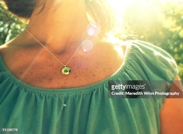 woman's neckline and necklace in sunshine - neckline stock pictures, royalty-free photos & images
