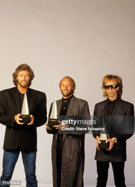 Portrait of the pop group the Bee Gees, from left, Barry Gibb, Maurice Gibb , and Robin Gibb , as they pose, each one with an American Music Awards...