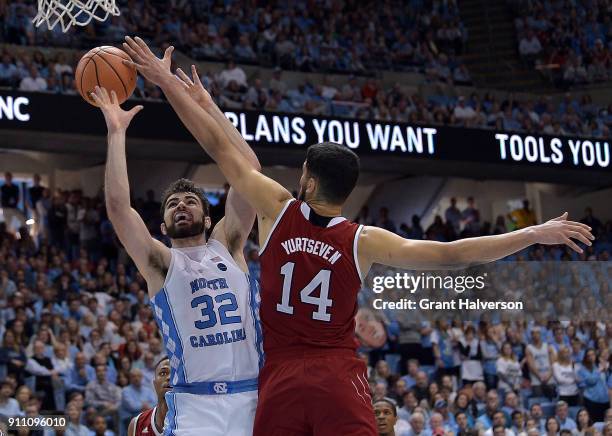 Omer Yurtseven of the North Carolina State Wolfpack defends a shot by Luke Maye of the North Carolina Tar Heels during their game at the Dean Smith...