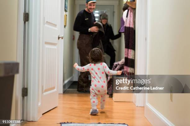 toddler running towards parents who've just returned home - homecoming photos et images de collection