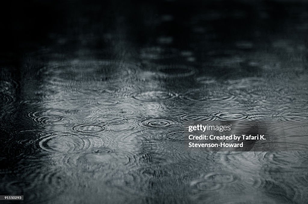 Ripples of raindrops in puddle