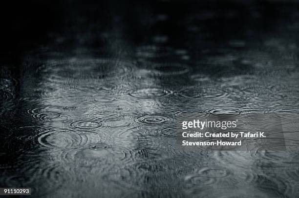 ripples of raindrops in puddle - rain drops stockfoto's en -beelden