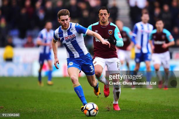 Callum Elder of Wigan Athletic in action with Javier Hernandez of West Ham United during the Emirates FA Cup Fourth Round match between Wigan...