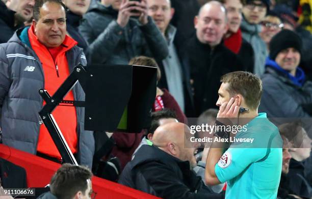 Craig Pawson, match referee, watches the VAR screen before awarding a penalty to Liverpool during The Emirates FA Cup Fourth Round match between...