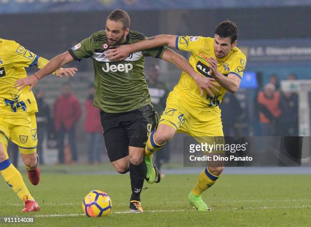 Gonzalo Higuain of Juventus competes with Nenad Tomovic of Chievo Verona during the serie A match between AC Chievo Verona and Juventus at Stadio...